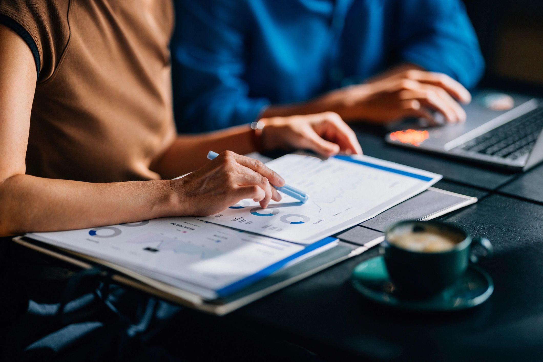 Two colleagues reviewing financial data and charts in an office